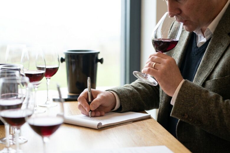 Un critique dégustant du vin et prenant des notes lors d'une séance professionnelle