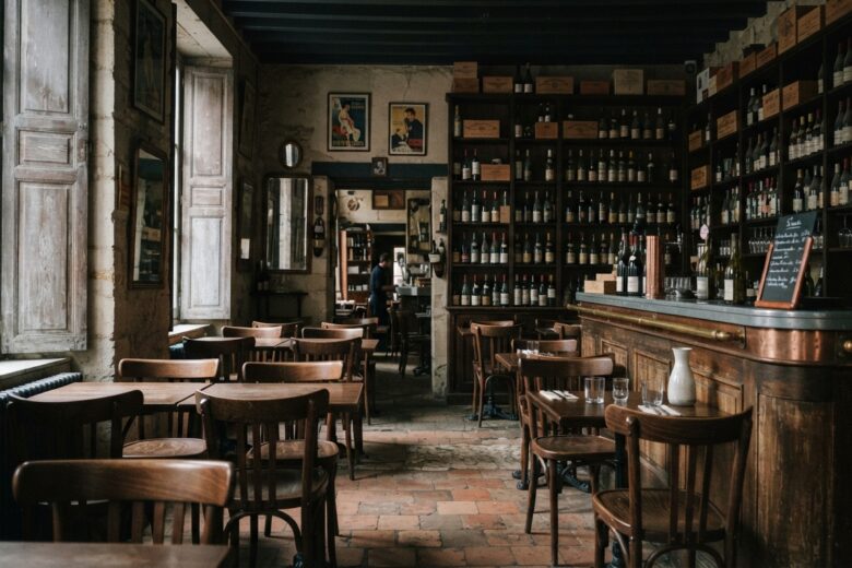 Intérieur d'un bar à vin traditionnel avec tables vides et bouteilles de vin alignées sur les étagères